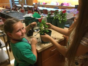 girl planting flower in pot